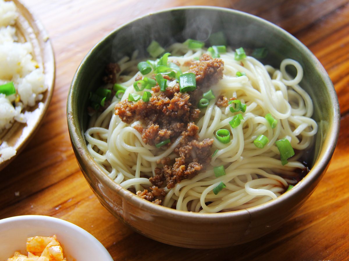 A bowl of dan dan noodles with spicy sauce