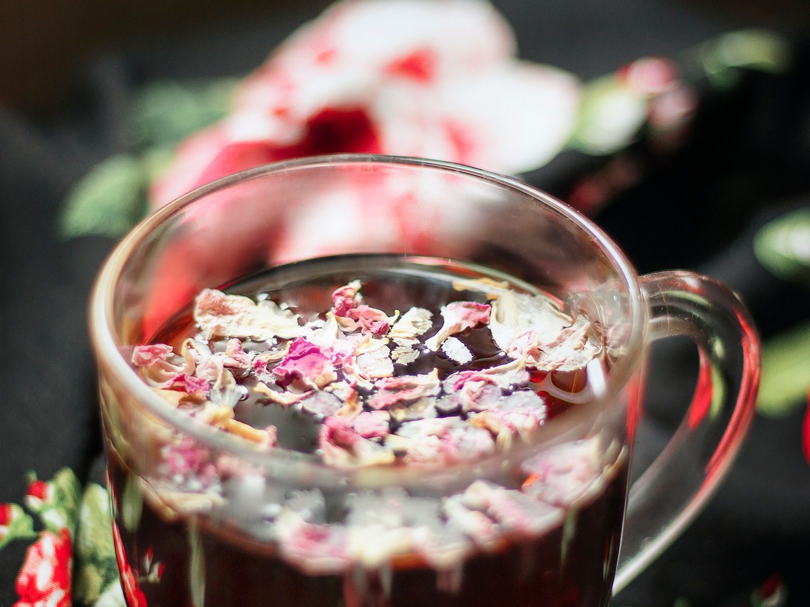 Glass cup of herbal tea infused with dried flower petals