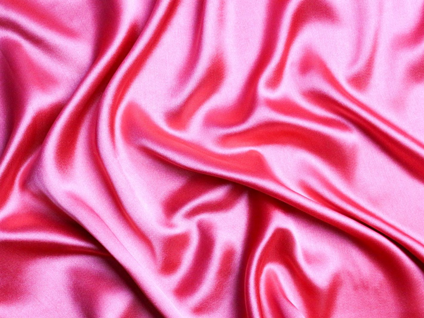 Close-up of smooth pink silk fabric with elegant folds