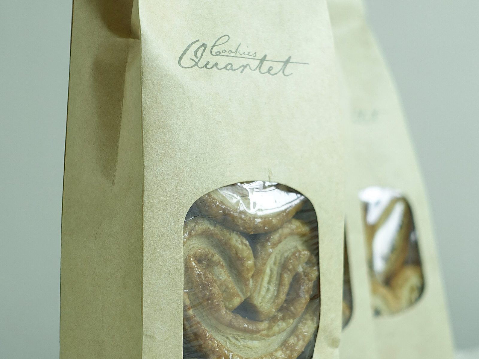 Packaged palmier butterfly cookies in a kraft paper gift bag