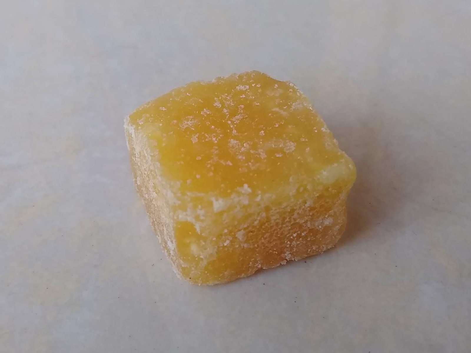 A single amber pear-syrup candy cube